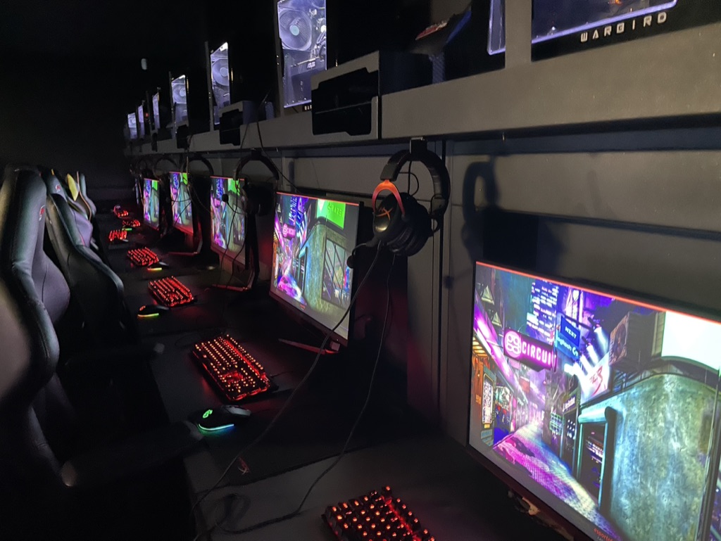 esports arena, row of lit up computer screens and keyboards
