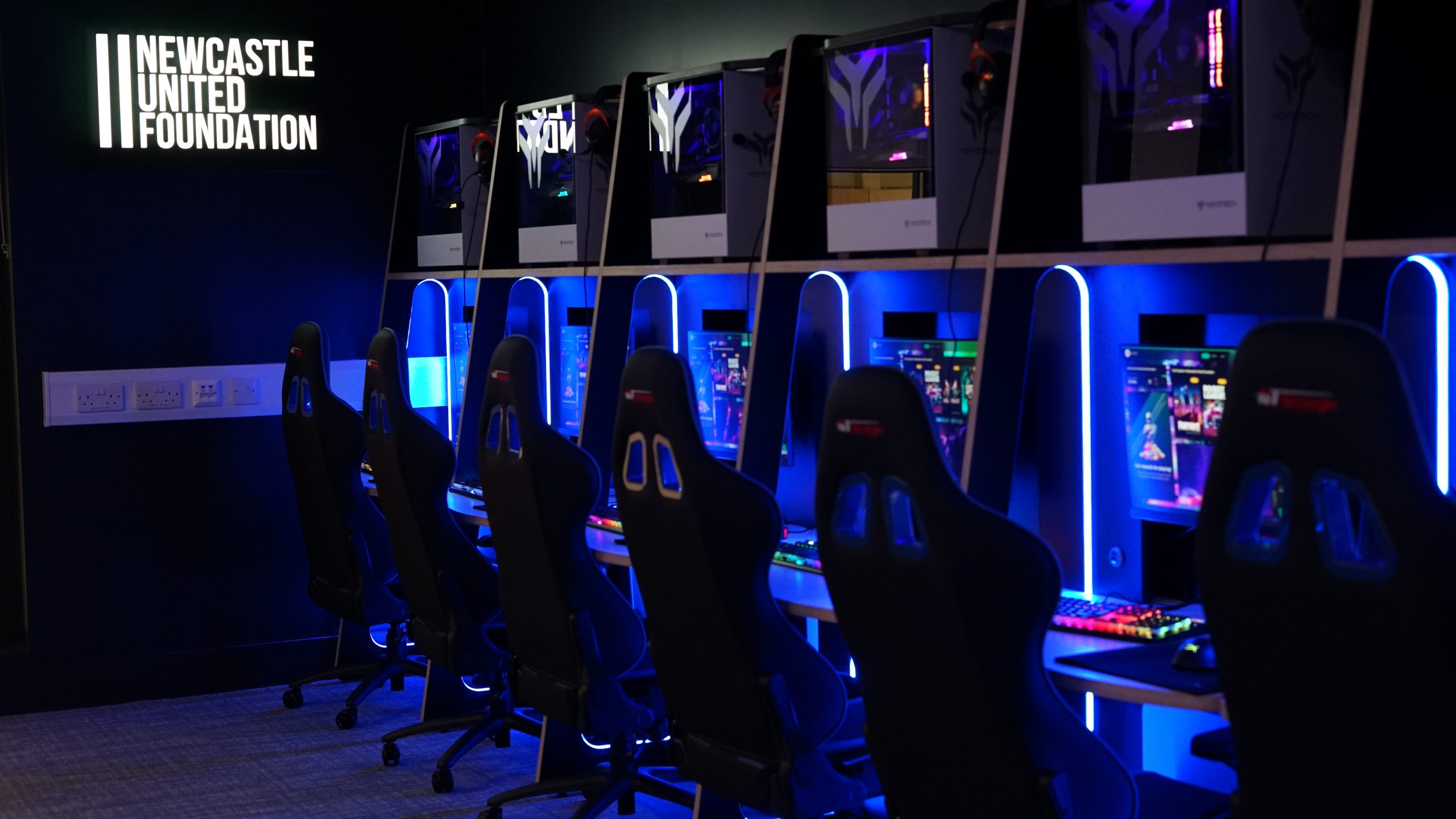 Nucastle finished esports arena showing desks and screen with lighting